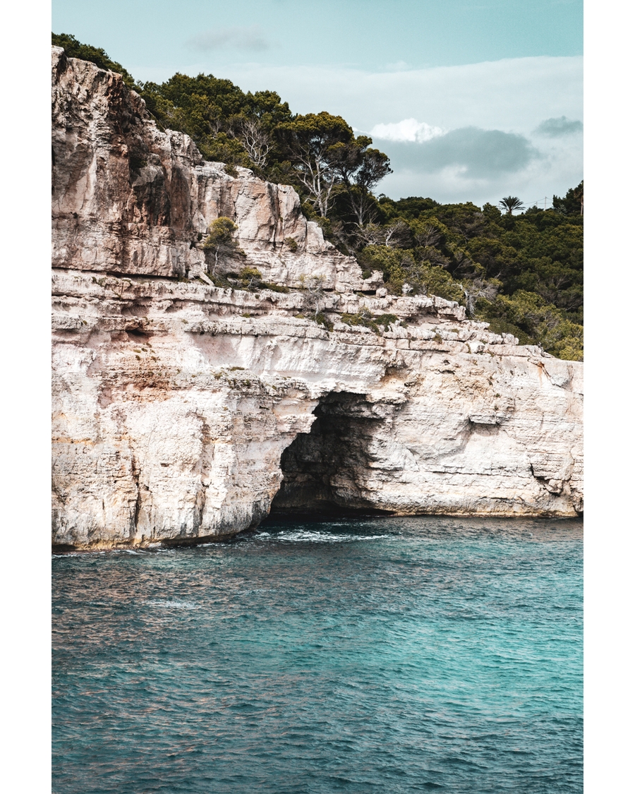 Coastal limestone cliffs with turquoise sea and greenery