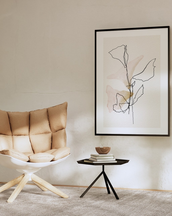 One Line Leaves poster in a slim black frame above a small side table in a beige minimalist living room