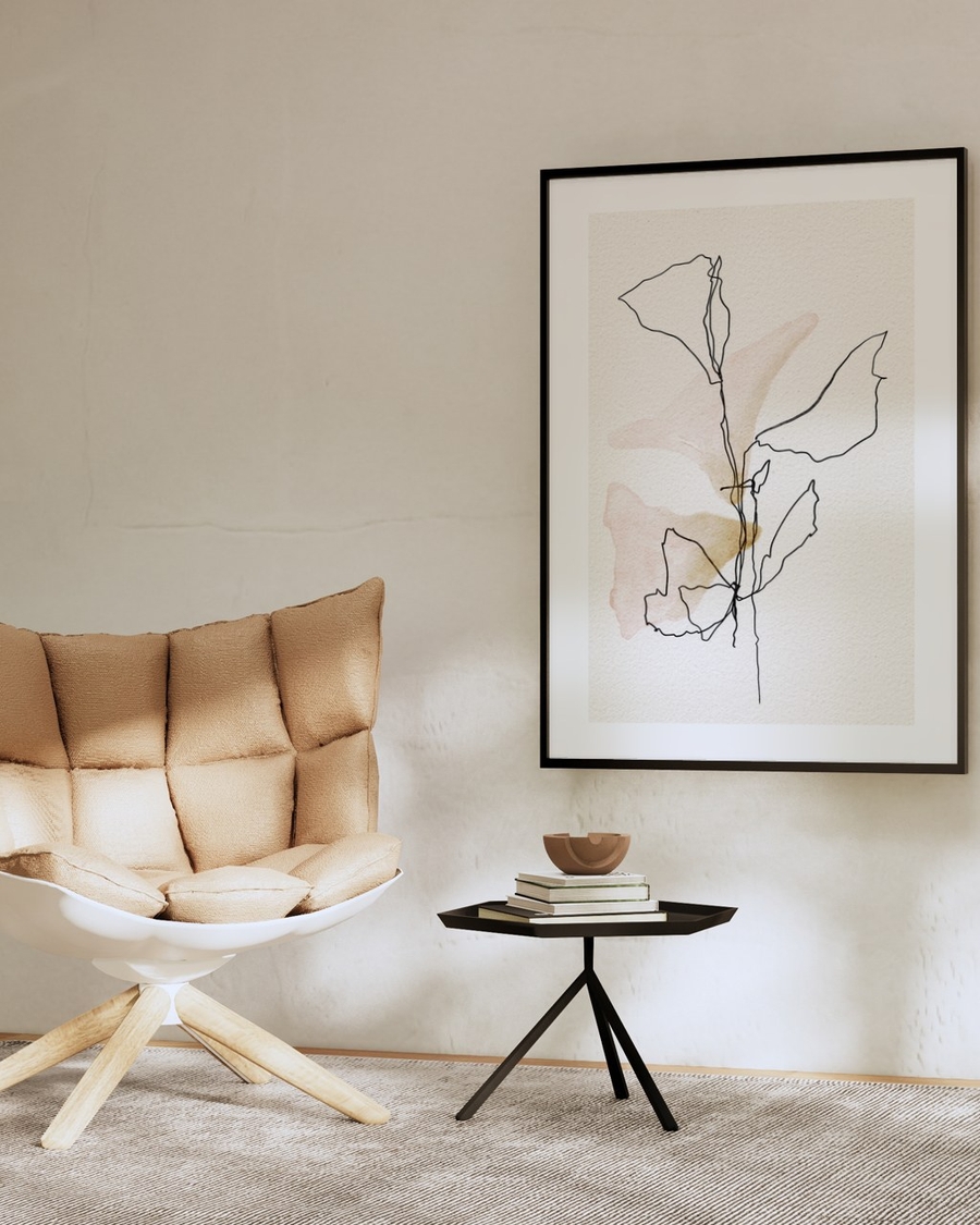One Line Leaves poster in a slim black frame above a small side table in a beige minimalist living room