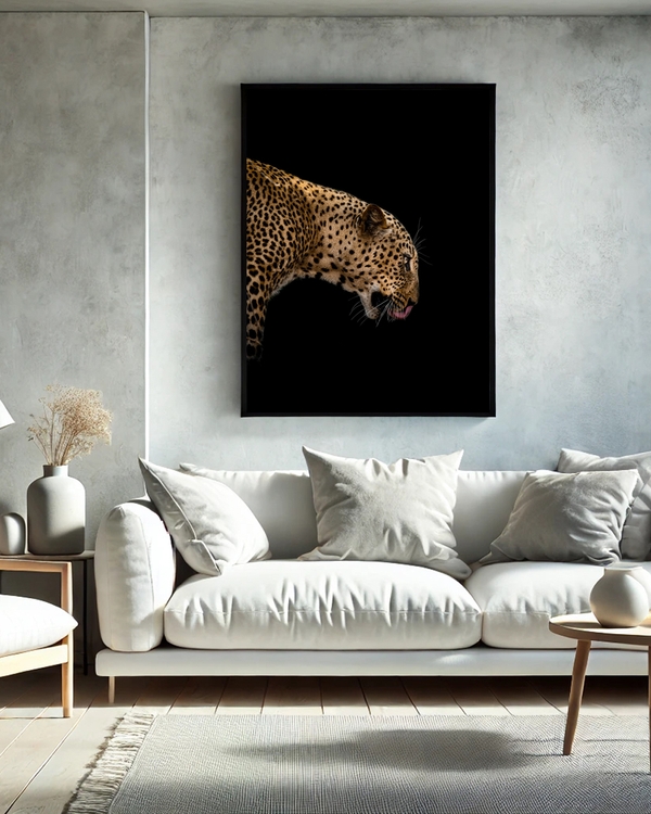 A framed poster of a focused leopard on a black background hanged on a white wall