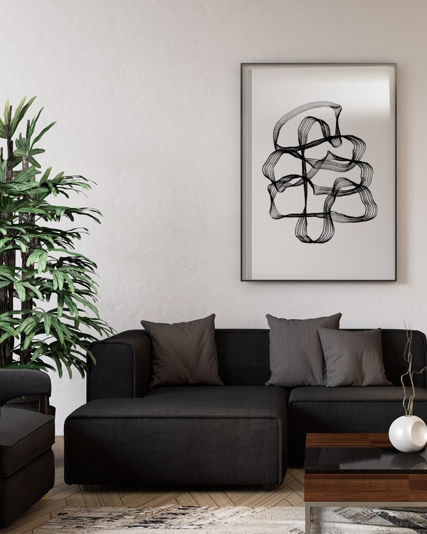 Looping Ribbons poster in a slim black frame above a dark grey sofa in a modern living room