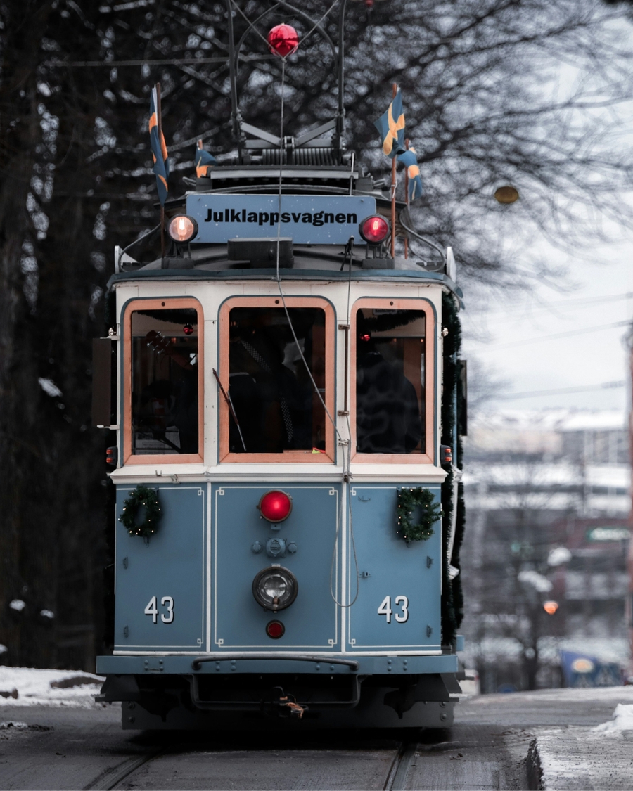 Blue vintage tram decorated for Christmas on snowy street