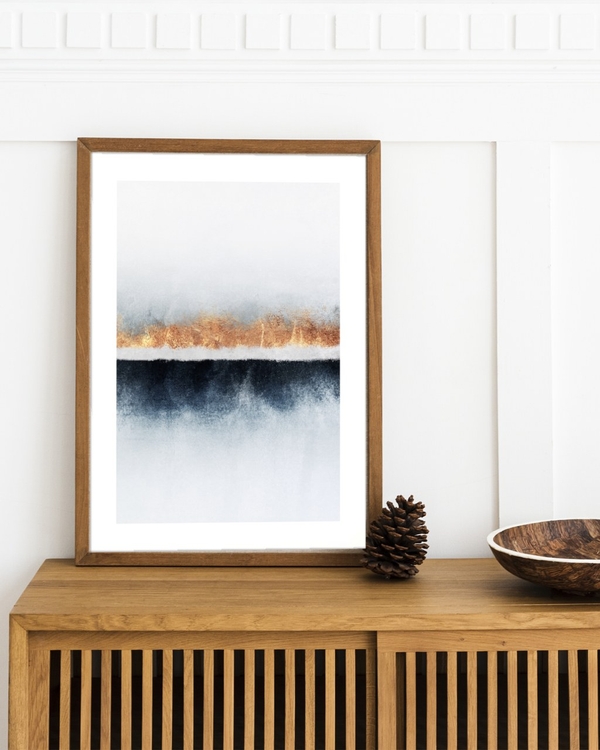 Copper Seam poster in a wooden frame leaning on an oak sideboard against white panelled wall