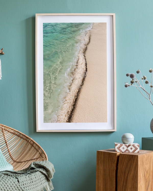 a poster of a close-up of turquoise ocean waves washing onto sandy beach