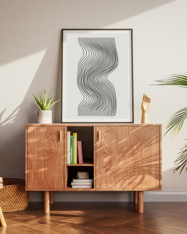 Poster one of black waves on a off-white background placed on a brown table