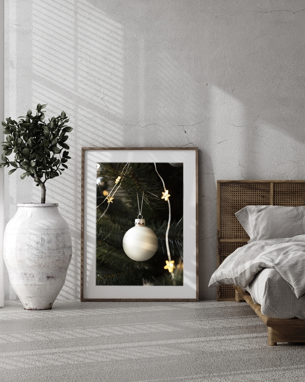 A poster of White a Christmas ornament hanging on tree with star lights