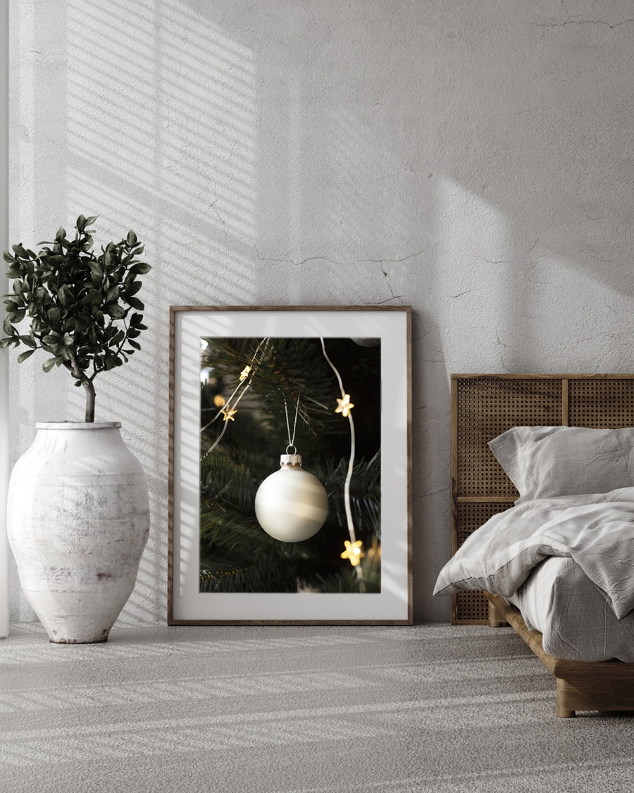 A poster of White a Christmas ornament hanging on tree with star lights