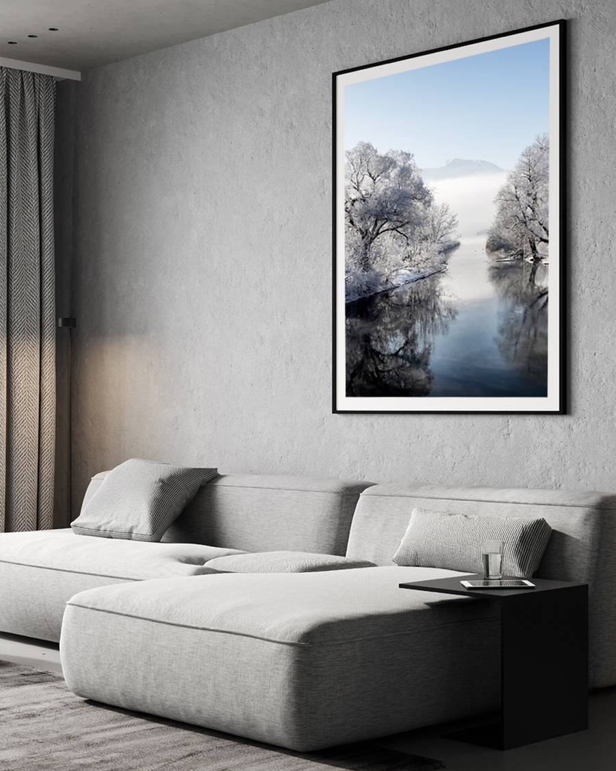 Snow-covered trees and calm river in winter landscape