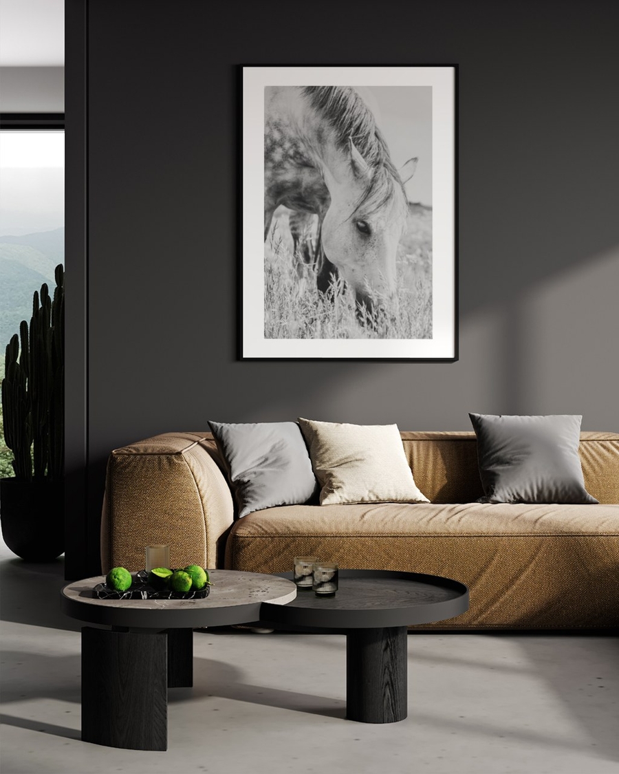 Grazing in Tall Grass poster in a slim black frame on a dark grey wall above a beige sofa