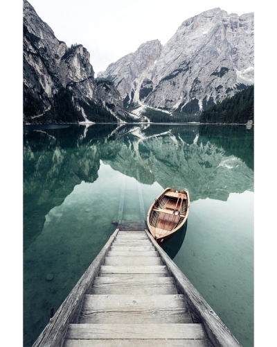 Wooden dock and boat on calm mountain lake