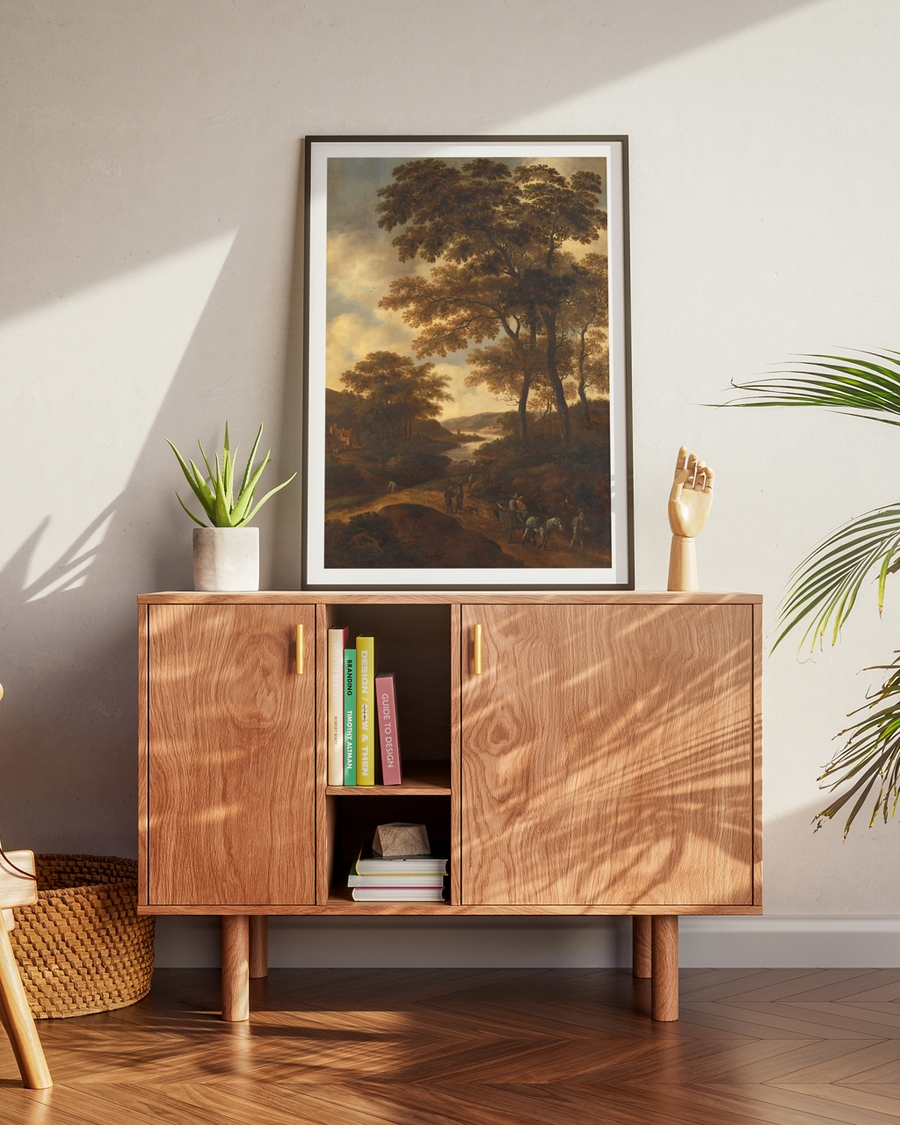 A poster of a painting of a group of travellers in a valley placed on a table