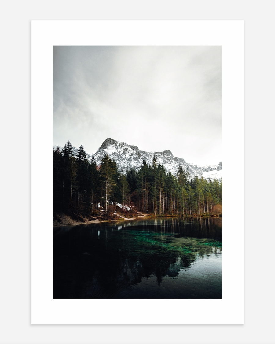 A poster of a Mountain lake with forest and snowy peaks reflected
