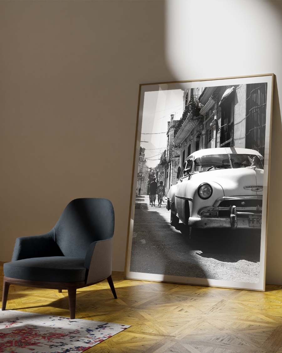 A poster of a Classic car parked on narrow street with old buildings