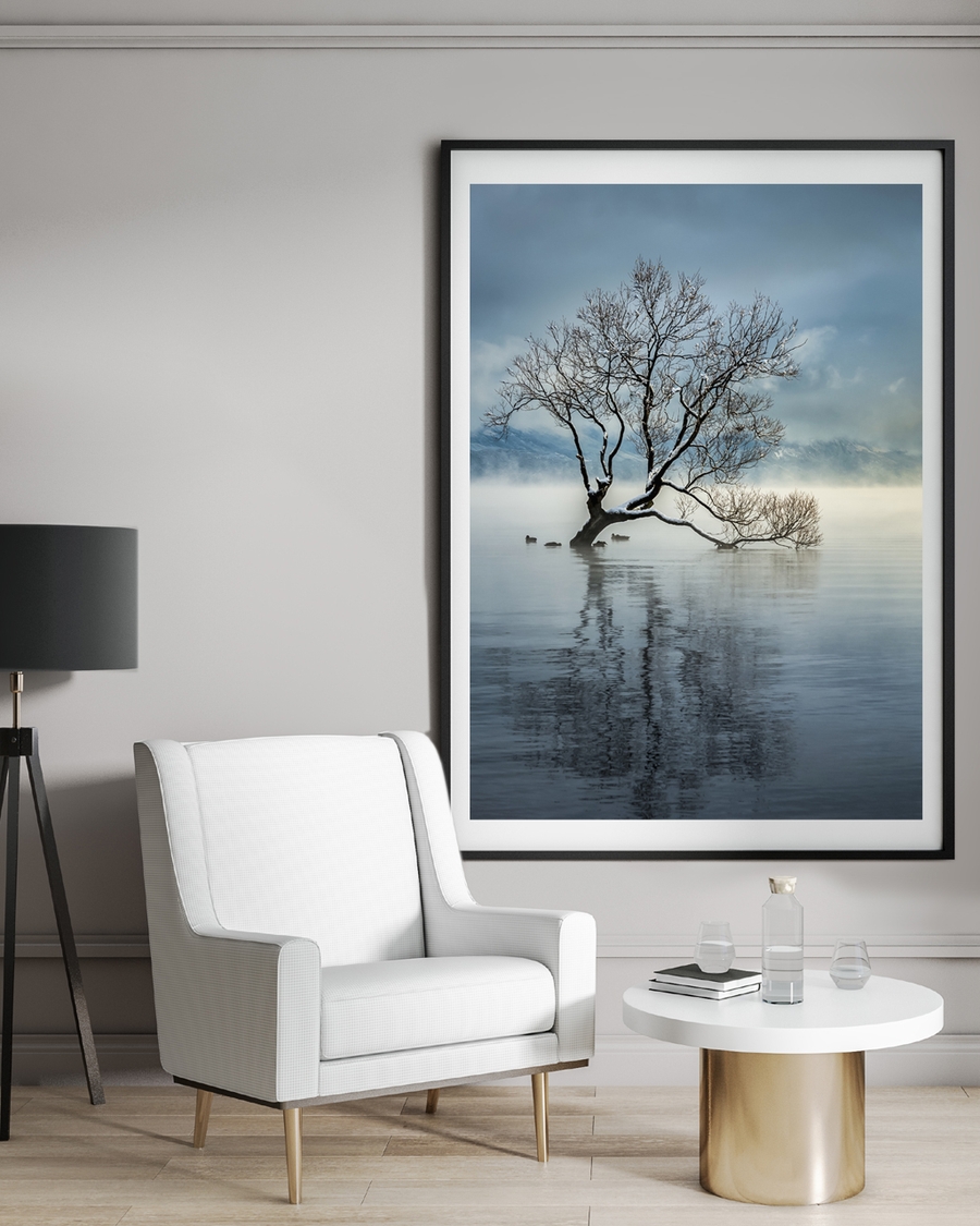 A poster of a lone tree in misty water with soft reflections