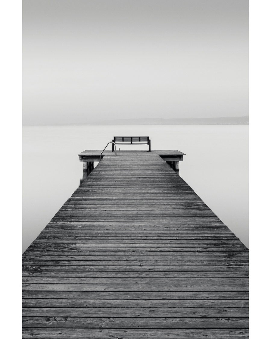 Wooden pier leading into calm water and horizon