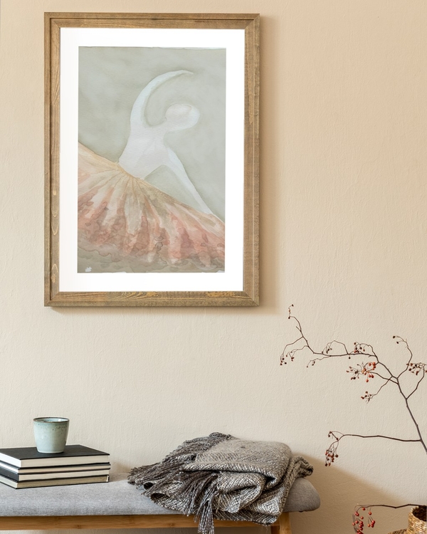 Peach Tulle Dancer poster in a rustic wooden frame above a bench with folded throw