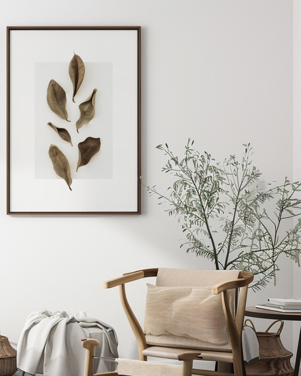 Dried Leaf Study poster in a dark wood frame above a wooden chair and leafy plant