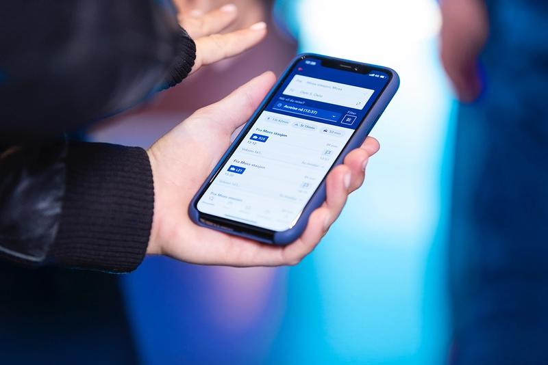 Bilde av en hånd som holder opp en mobiltelefon innlogget på Entur-appen.