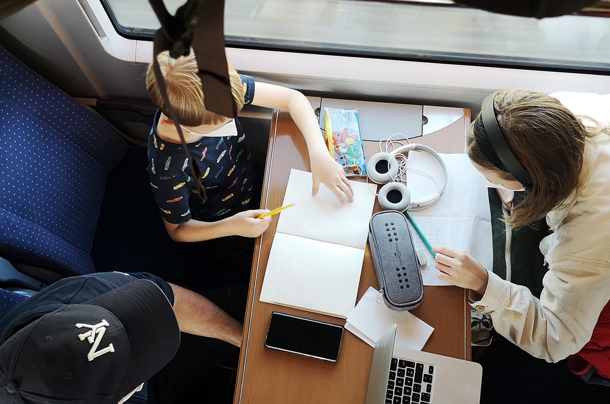 Togkupe fra fugleperspektiv. Familien holder på med lekser og skriving.