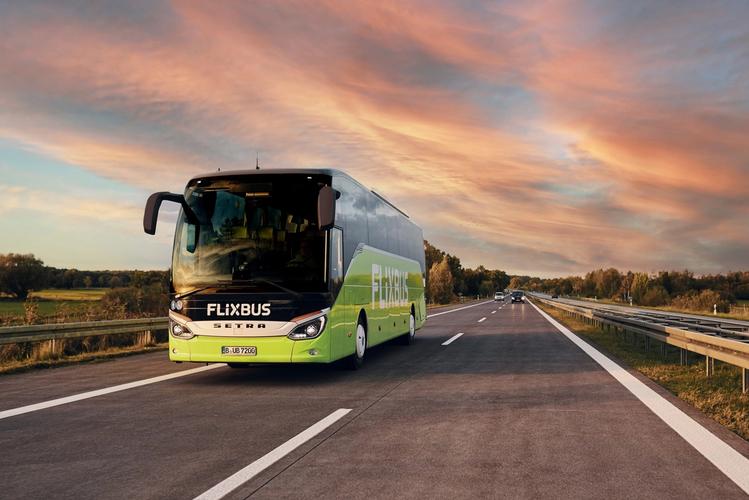Bilde av en buss som kjører på en motorvei. Bussen er grønn, og det står Flixbus på fronten.