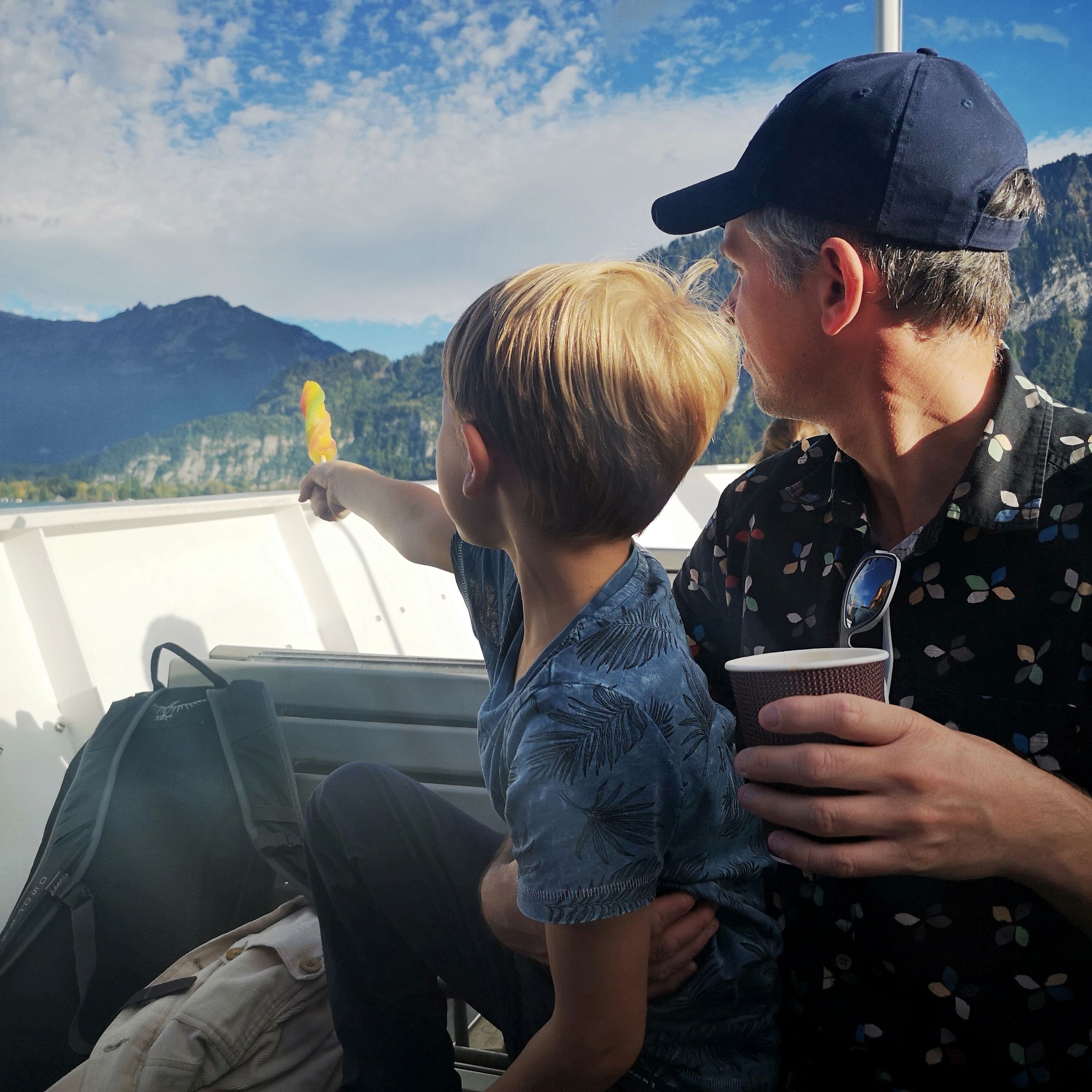 Faren og sønnen ser ut på Thune-sjøen fra en båt. 