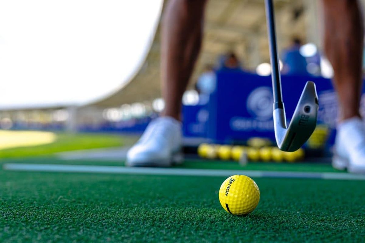 Close-up of a golf ball and club on the driving range mat at Golf Central