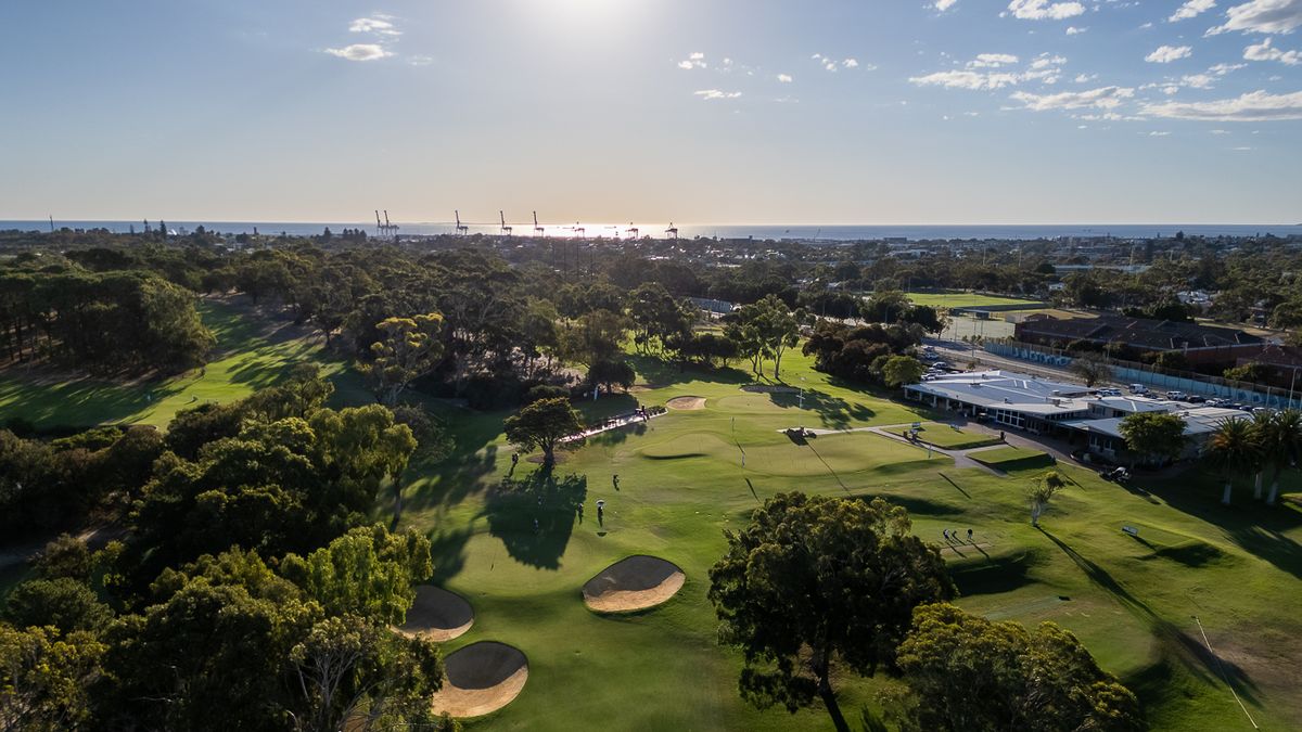 Aerial view of a bunkered green at Royal Fremantle Golf Club, Perth, with the port and ocean beyond