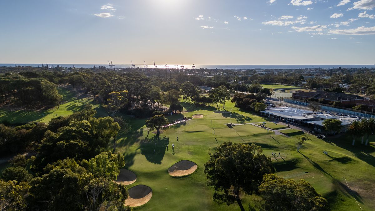 Aerial view of a bunkered green at Royal Fremantle Golf Club, Perth, with the port and ocean beyond