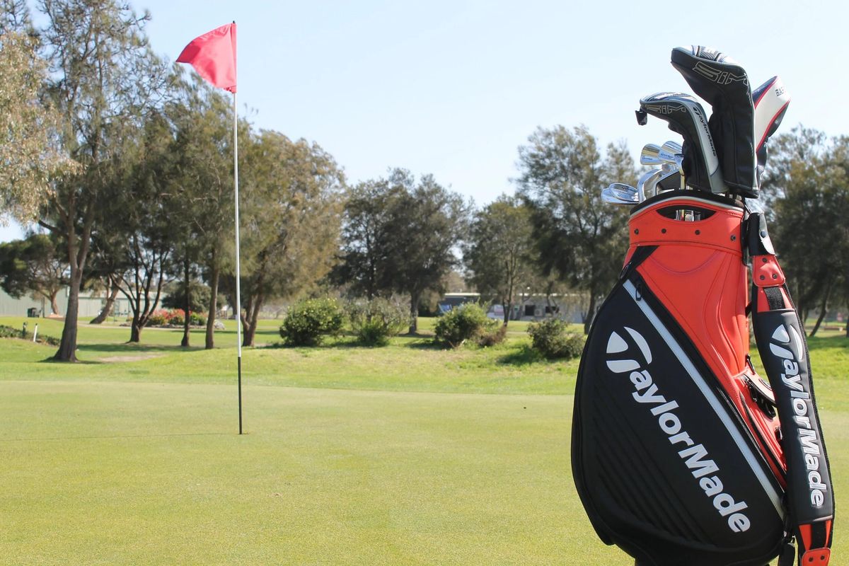 A green with the flag flying at Barwon Valley Golf Club, golf bag in the foreground and trees lining the fairway.
