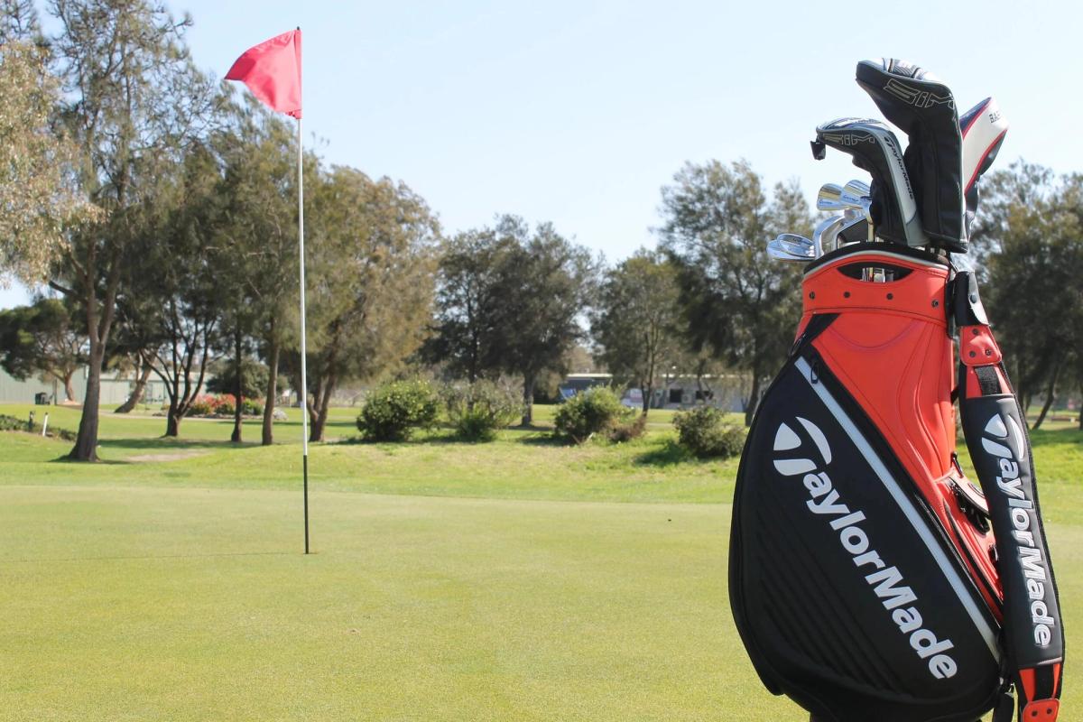 A green with the flag flying at Barwon Valley Golf Club, golf bag in the foreground and trees lining the fairway.
