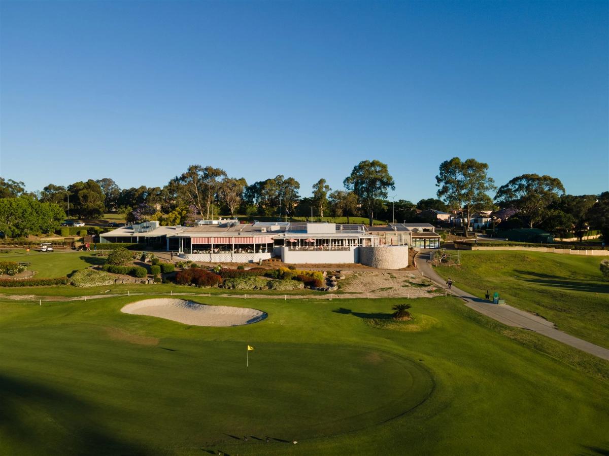 Aerial view of the clubhouse and a bunkered green at Campbelltown Golf Club, with the fairway in the foreground.