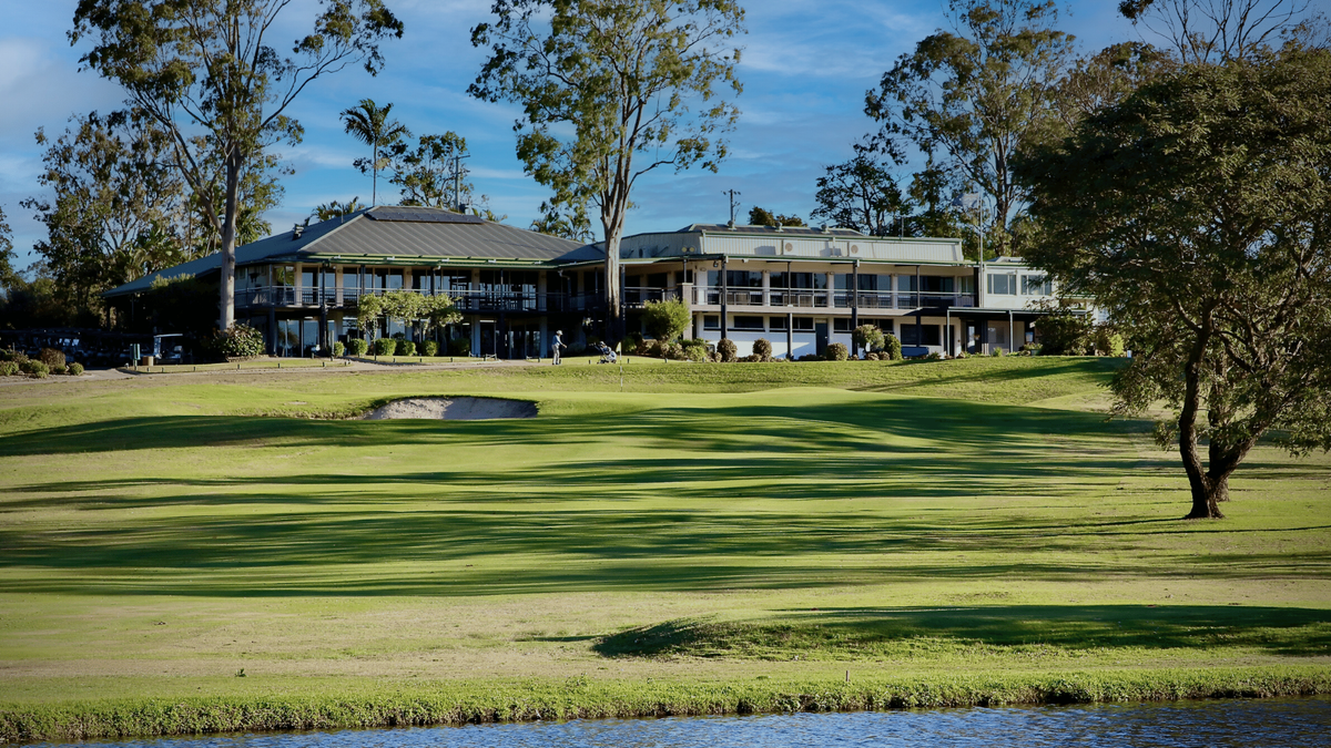 The clubhouse at McLeod Country Golf Club, Brisbane, seen across a green with a bunker