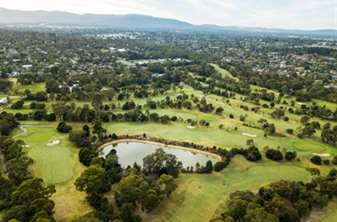 Aerial view of Ringwood Golf Course fairways and a pond surrounded by trees