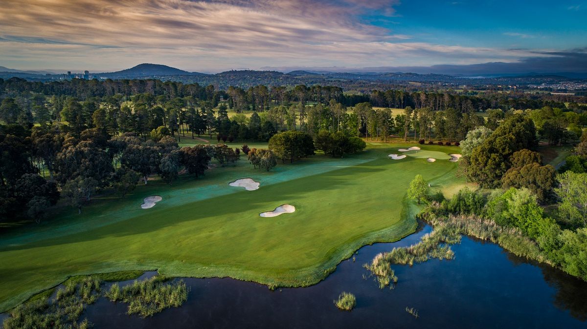 Aerial view of a fairway and green at Royal Canberra Golf Club, with Canberra's skyline and hills in the background