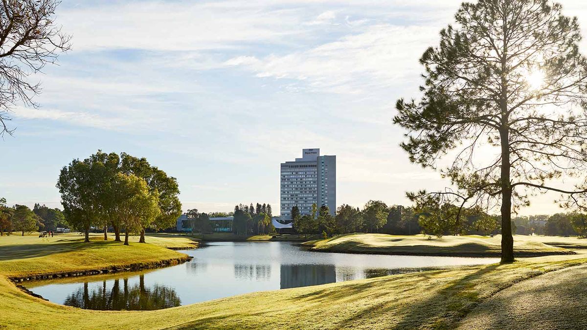 Golf course lake and fairway at RACV Royal Pines Resort with the hotel tower behind