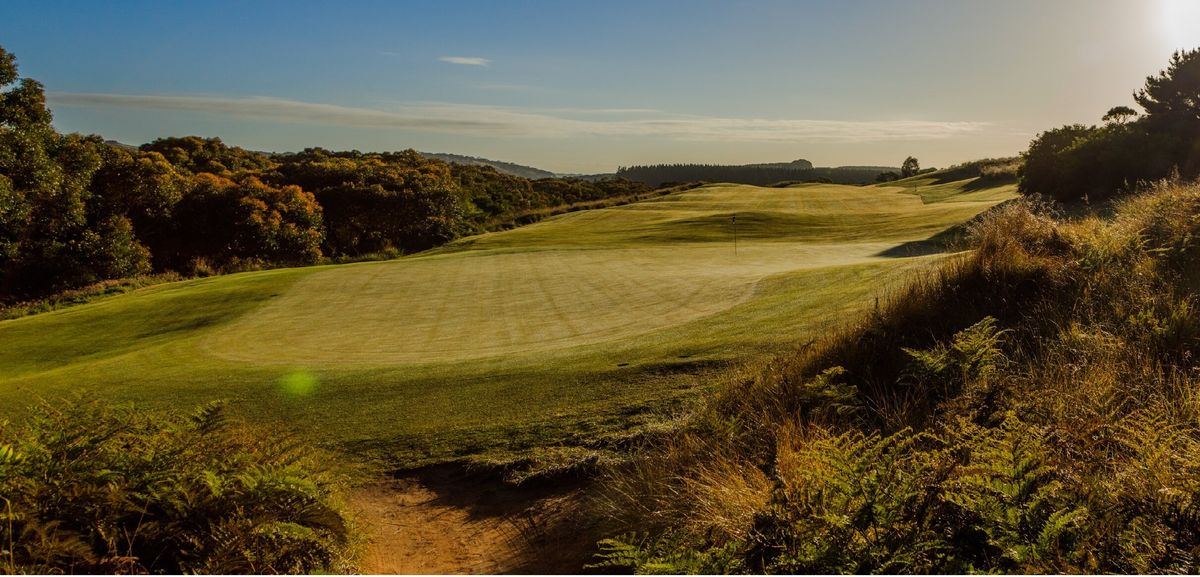A green and fairway at Mount Compass Golf Course with bunkers and native bushland