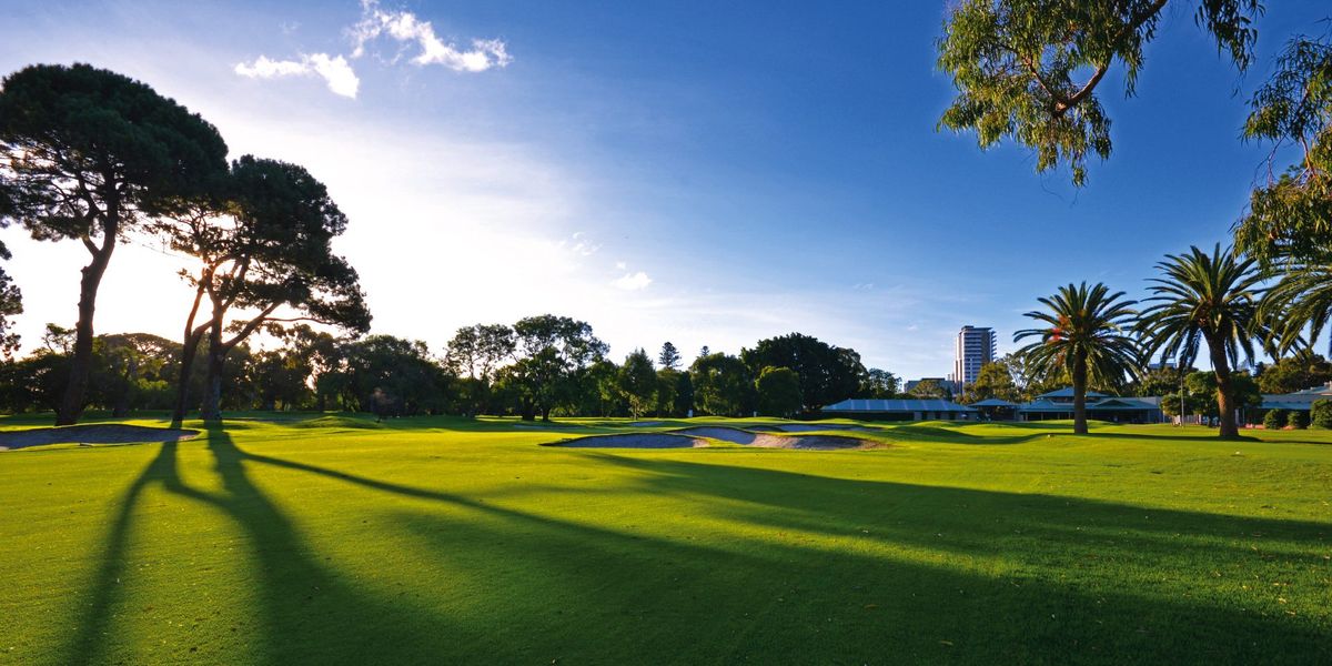 Fairway, bunkers and clubhouse at Royal Perth Golf Club with the city skyline behind