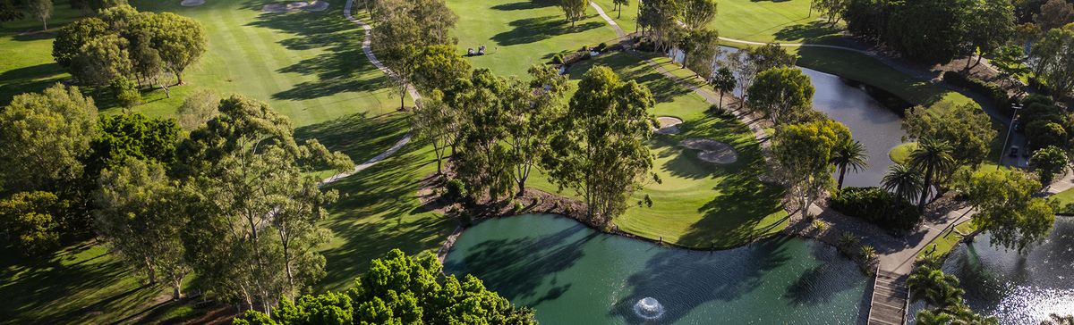 Aerial view of a green surrounded by bunkers and a lake at Emerald Lakes Golf Club