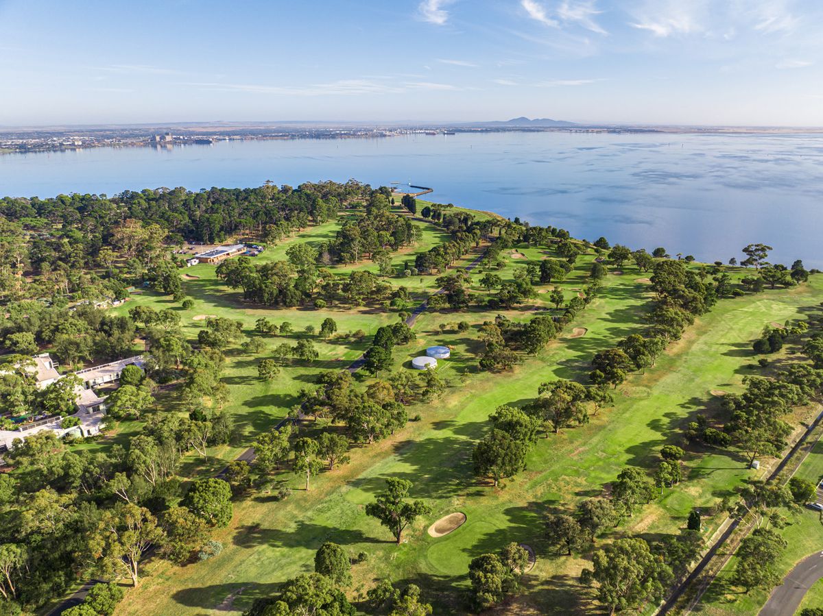 Aerial view of East Geelong Golf Club's tree-studded fairways alongside Corio Bay.