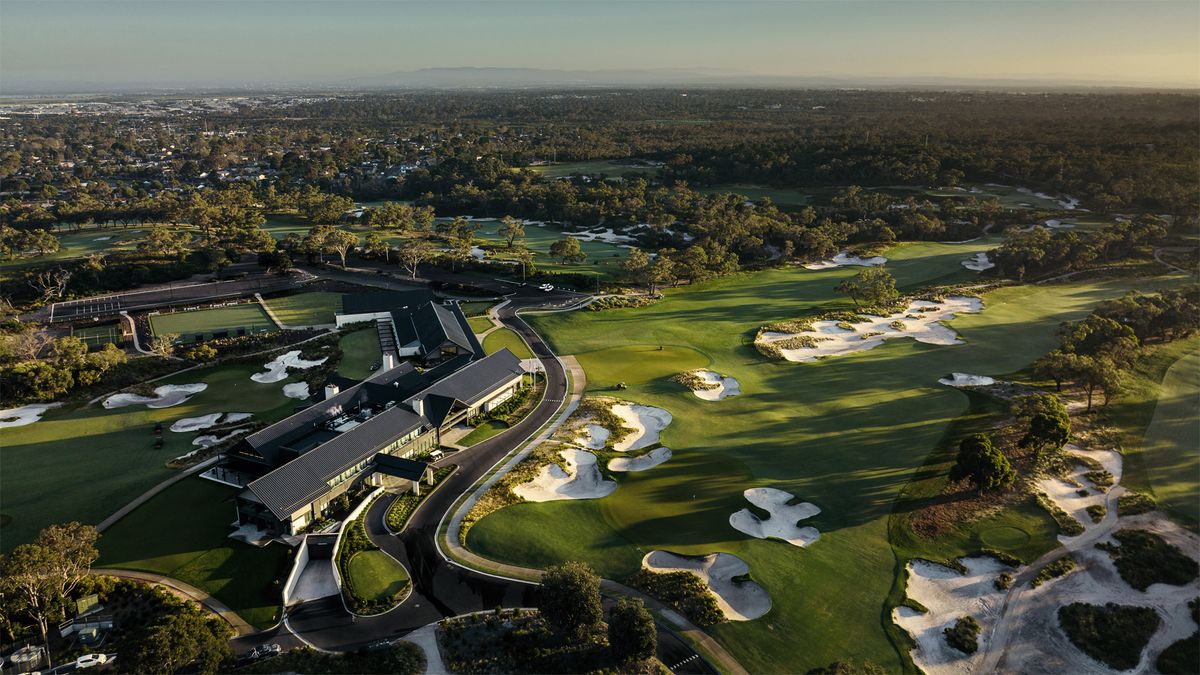 Aerial view of the clubhouse and bunkered fairways at Peninsula-Kingswood Country Golf Club, Melbourne, at sunset