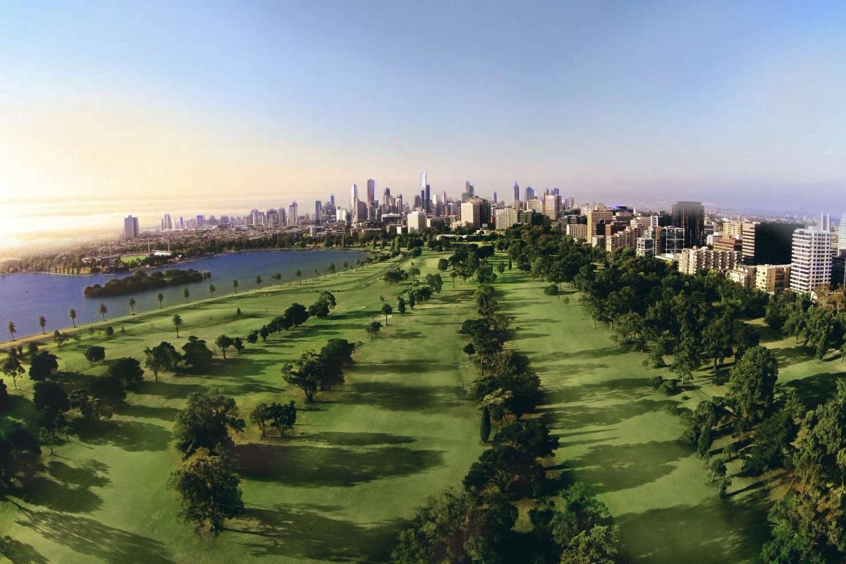 Aerial view of Albert Park Golf Course fairways lined with trees, with Albert Park Lake and the Melbourne city skyline behind.