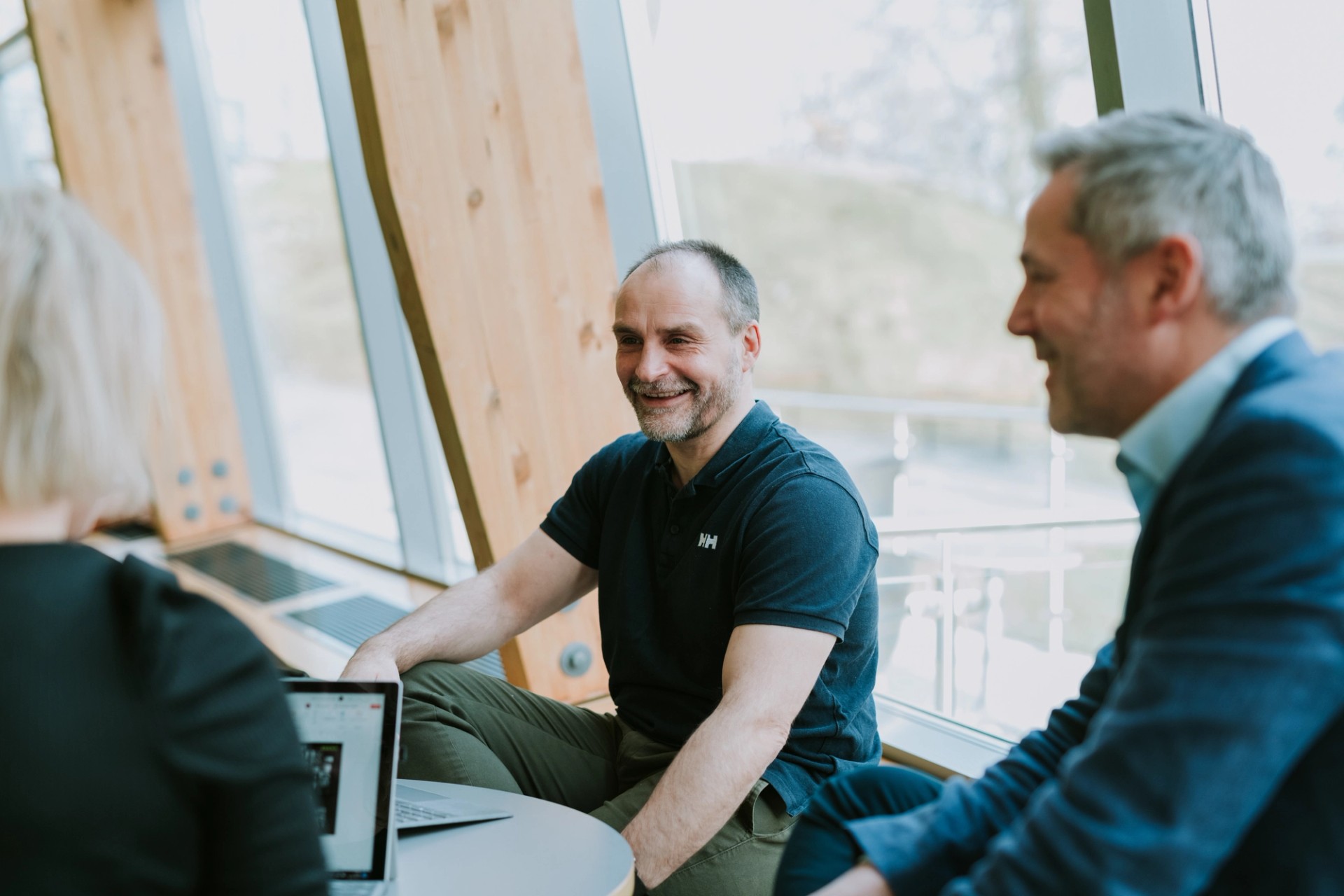 Three Solwr employees talking while sitting next to a window