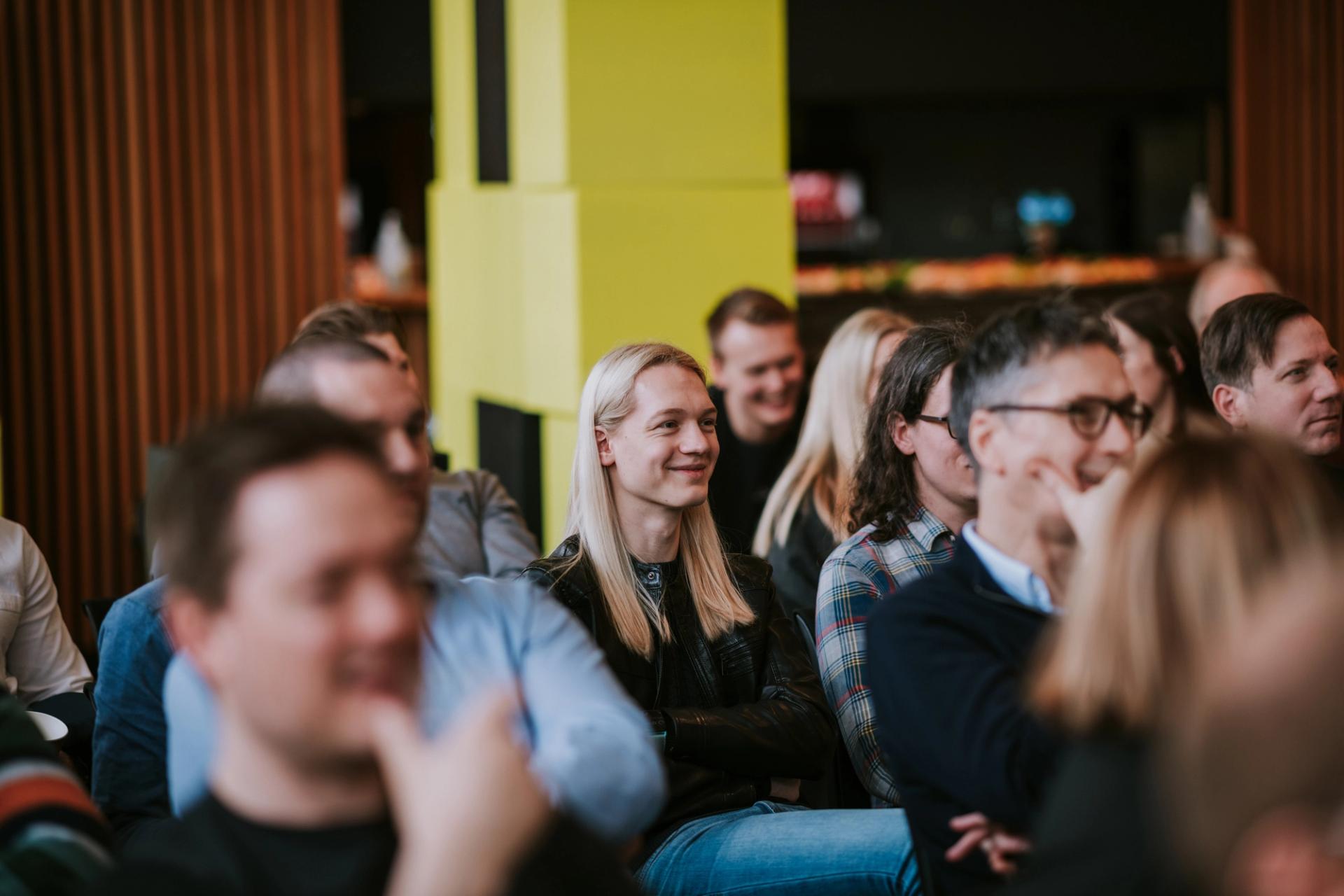 A crowd of Solwr employees looking at a stage during a corporate event