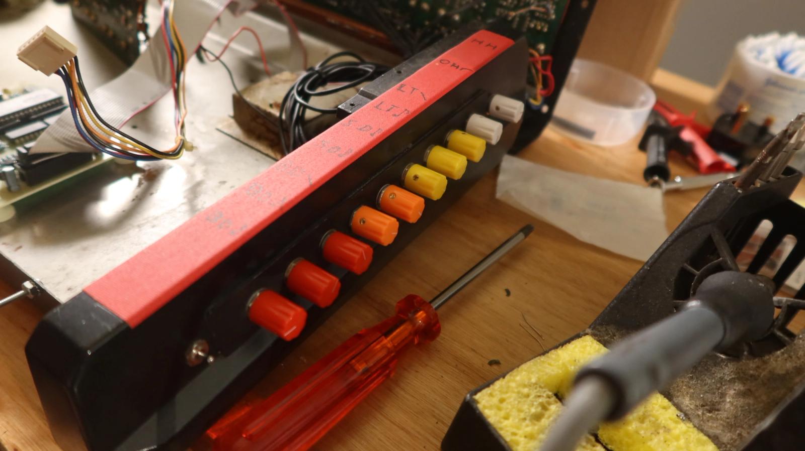The new control panel with its row of coloured knobs, a screwdriver beside it