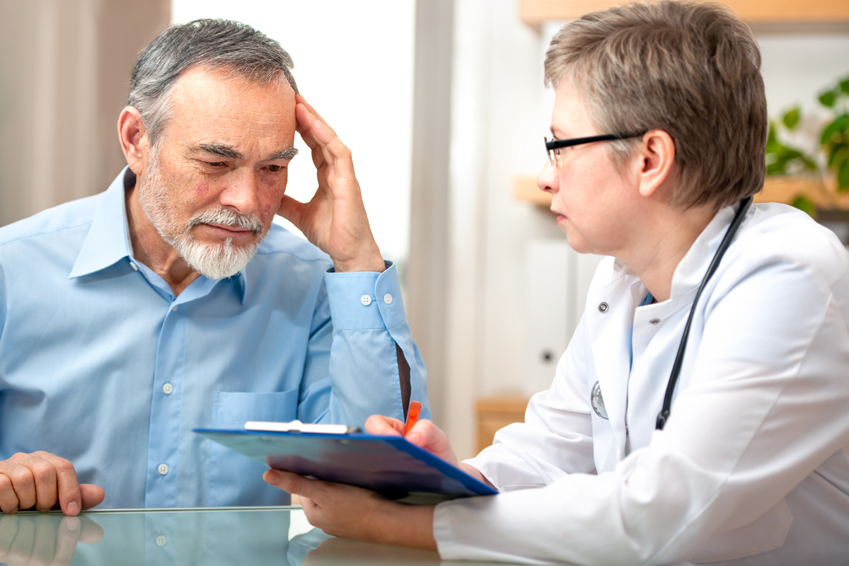 Doctor with clipboard speaking with patient