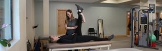 Physical therapist working with a woman's leg on a table