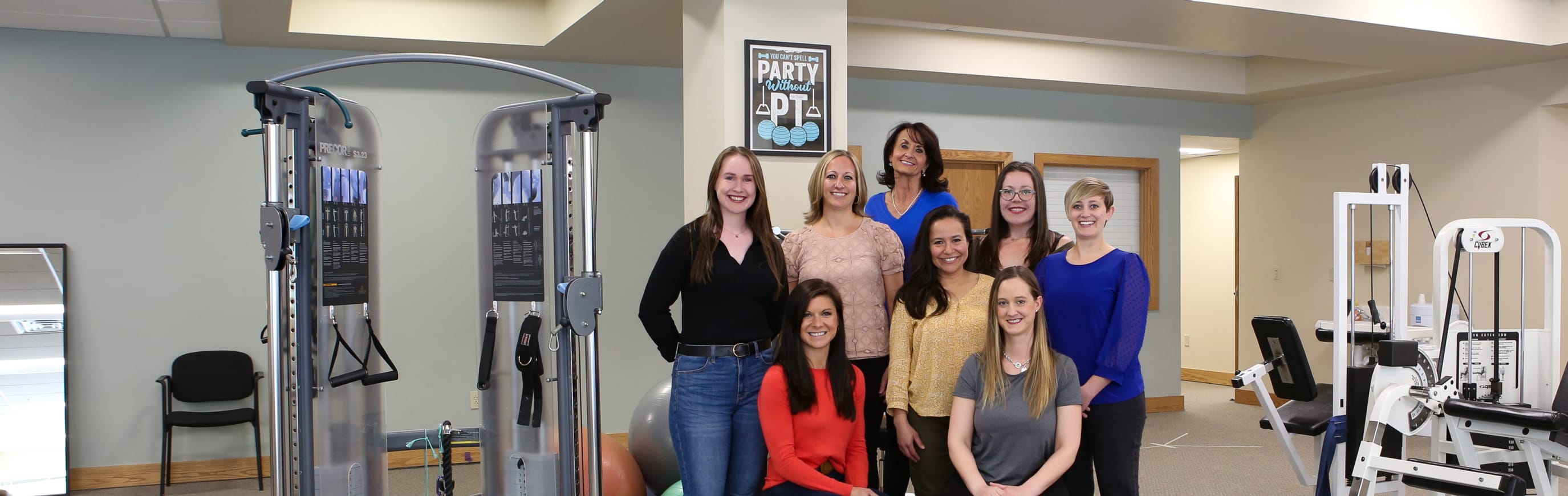 Several physical therapists in their clinic grouped together for a team photo