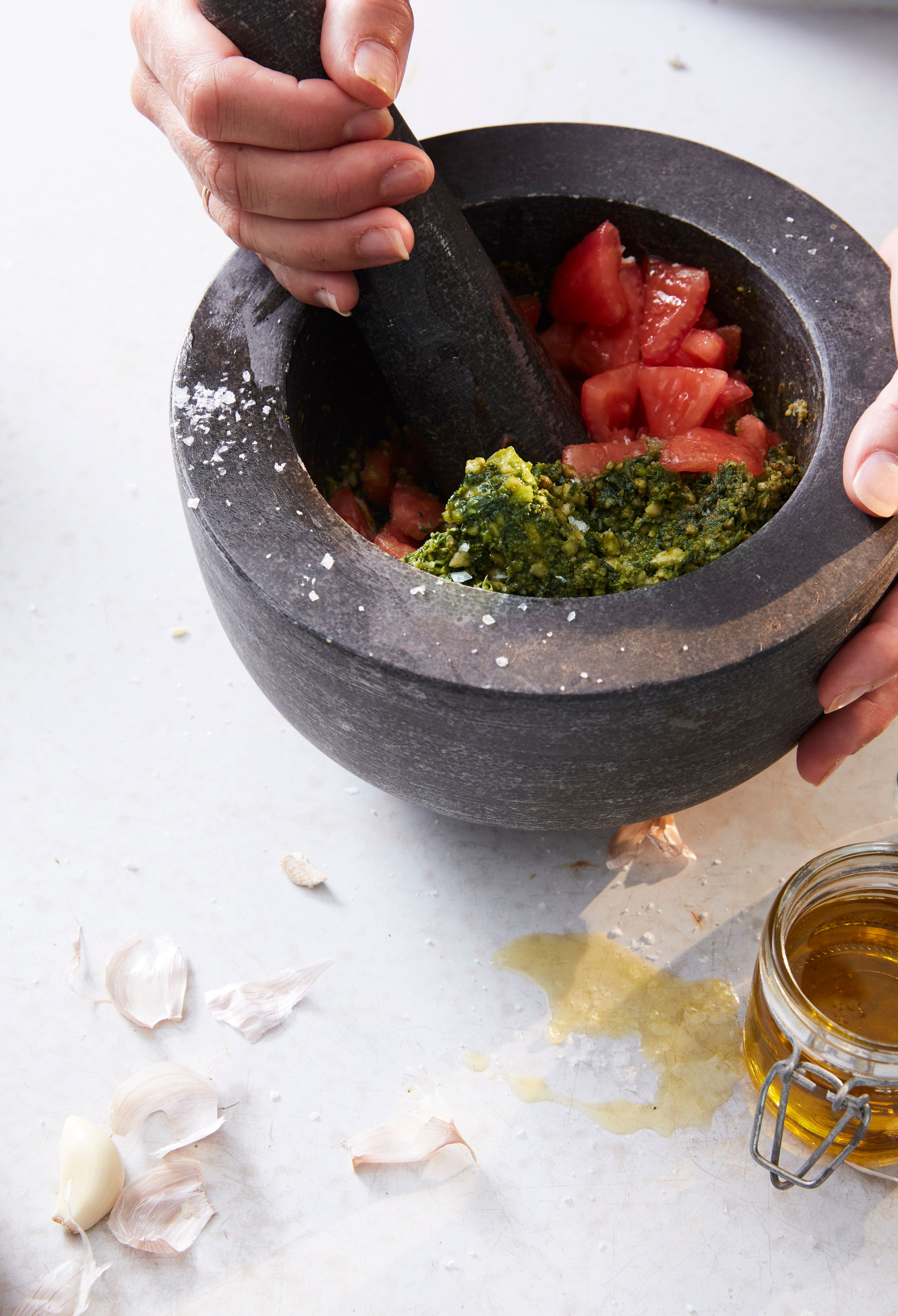Pesto being made in a mortar & pestle