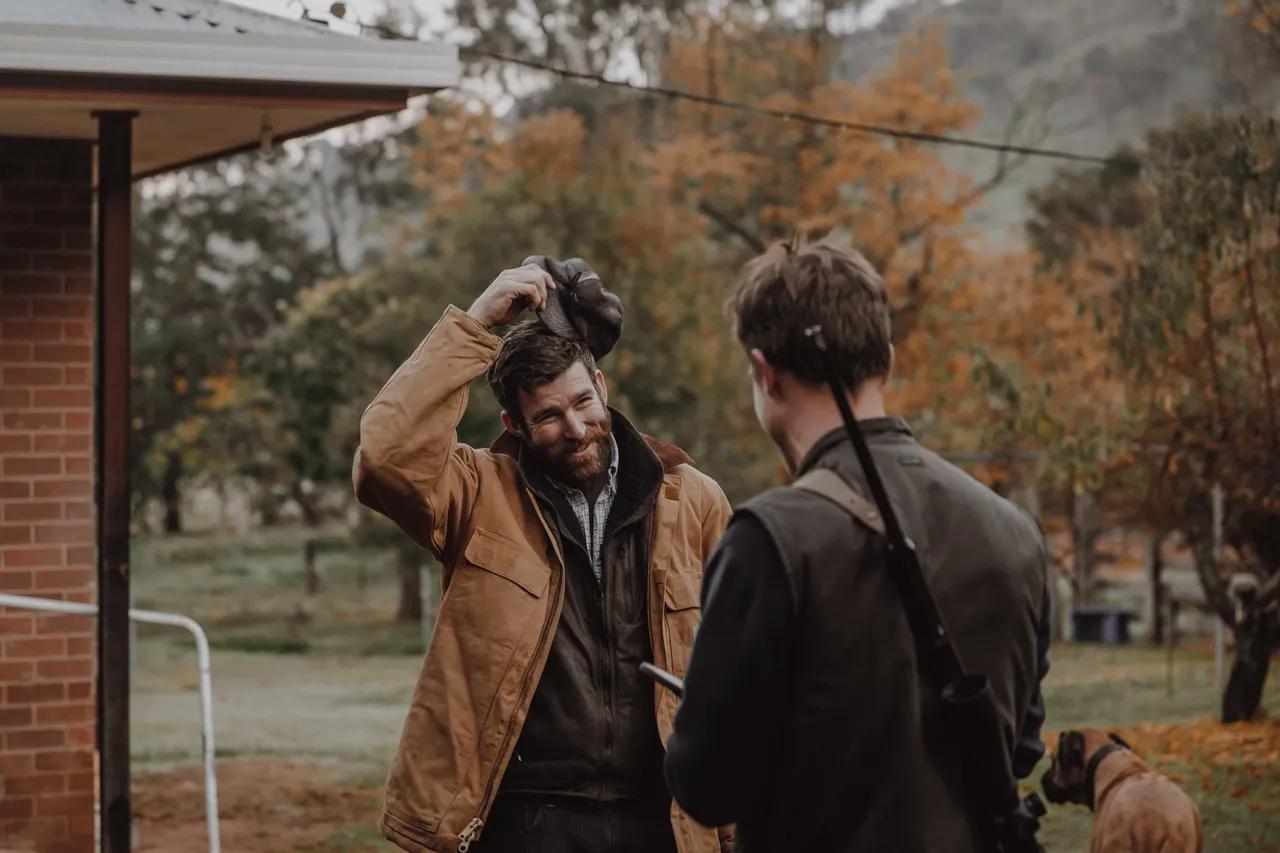 Two Men in hunting gear outside smiling