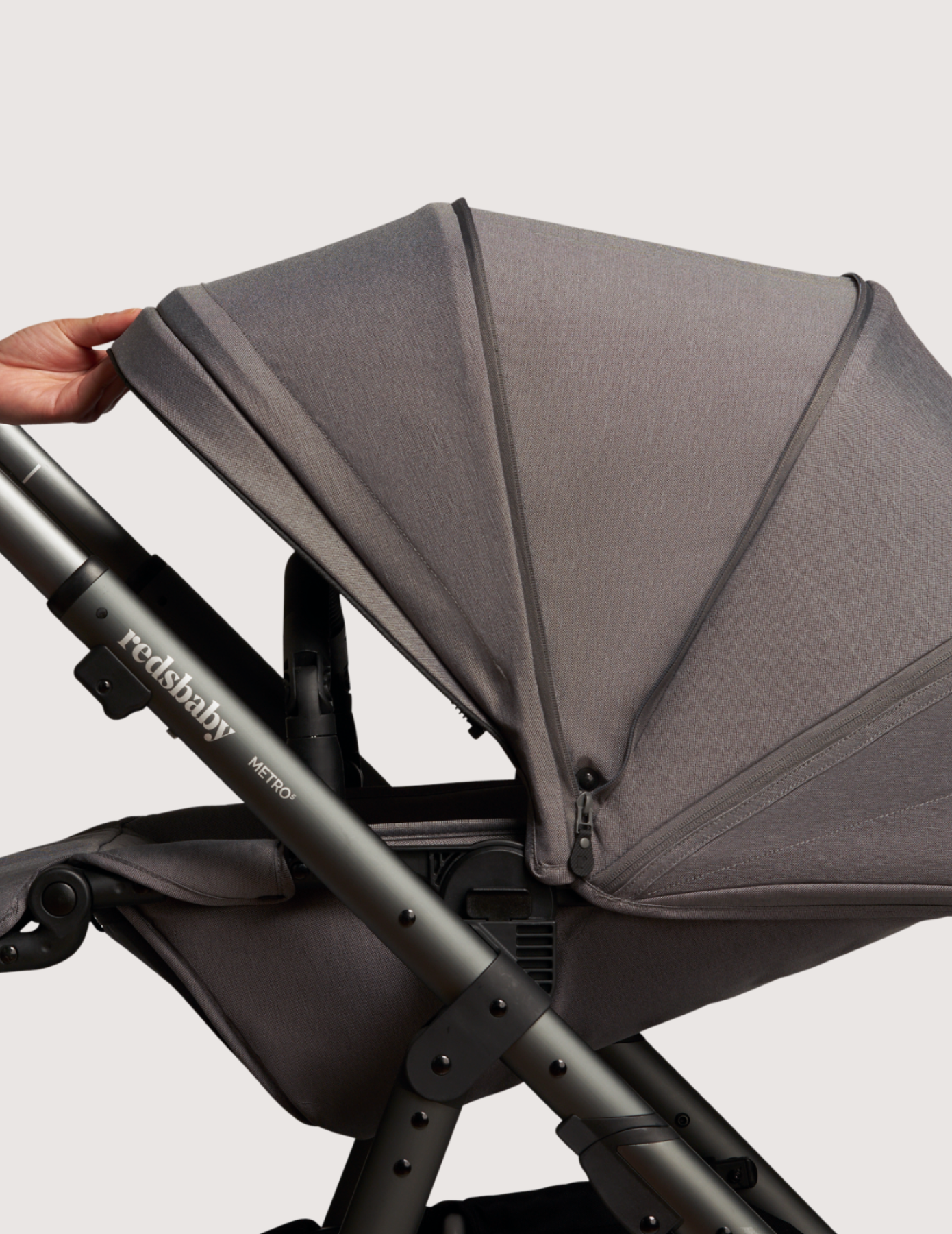 Redsbaby pram with a hand opening the canopy